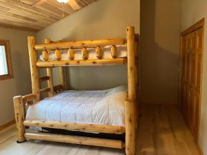 Łóżko piętrowe w pokoju obok ściany w obiekcie Deepwater Lodge Chicaugon Lake! 