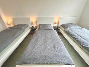 two twin beds in a room with two lamps at 3 Betten Unterkunft Vahrenwald-List in Hannover