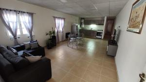 uma sala de estar com um sofá preto e uma cozinha em Descubre & Descansa em Tupungato