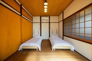 呉市にあるkamadomaの木製の壁の小さな部屋のベッド2台