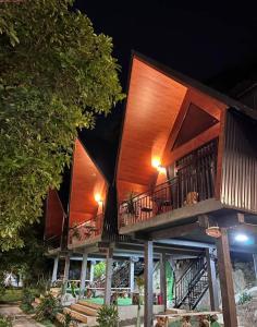 un gran edificio de madera con 2 terrazas por la noche en Lèn Chùa Ecostay en Phong Nha