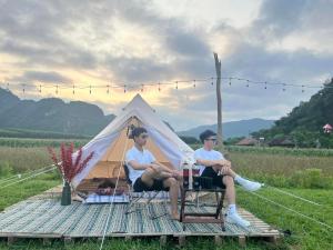 峰牙的住宿－Lèn Chùa Ecostay，两人坐在帐篷前的椅子上