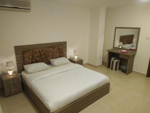 a bedroom with a large bed and a mirror at Rayan Hotel Suites in Amman