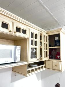 cocina con armarios de madera y microondas en Chalé Modesto, en Campos do Jordão