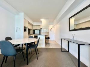 a dining room and kitchen with a table and chairs at BB on the Park 504 in Gold Coast