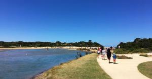 a group of people walking along a beach at Anglesea River Apartment 23 in Anglesea