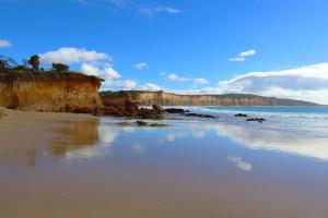 a beach with water and rocks and a blue sky at Anglesea River Apartment 22 in Anglesea