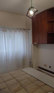 une chambre avec un grand lit et une fenêtre dans l'établissement Monoambiente Aldrey, à Mar del Plata