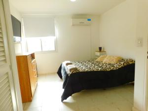 een slaapkamer met een bed en een raam bij DEPARTAMENTO Nº7 COMPLEJO PRIVADO in Godoy Cruz