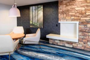 a lobby with a table and chairs and a stone wall at Fairfield Inn & Suites Bend Downtown in Bend