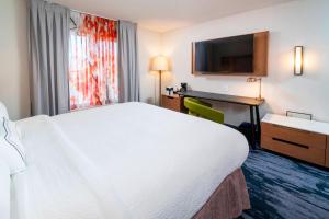 ein Hotelzimmer mit einem großen weißen Bett und einem Schreibtisch in der Unterkunft Fairfield Inn & Suites Bend Downtown in Bend