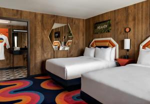 Cette chambre comprend 2 lits et 2 miroirs. dans l'établissement Americana Motor Hotel, à Flagstaff
