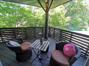 un porche con 2 sillas y una mesa en una terraza en プライベート温泉付き隠れ家　Shankara Lodge ~stay & retreat~ en Kirishima