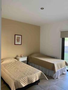 a bedroom with two beds and a picture on the wall at Casa con piscina en Maipú, Mendoza in Maipú +14 photos