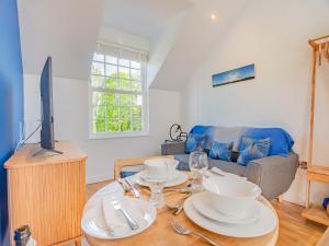 Gunns Loft في Smallburgh: غرفة معيشة مع طاولة وتلفزيون