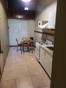 uma cozinha com uma mesa, um fogão, uma mesa e cadeiras em Monoambiente amplio, Centrico em Santa Rosa