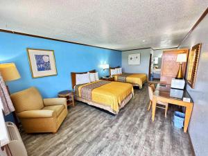 a hotel room with two beds and a chair at Night Inn in Sweet Springs