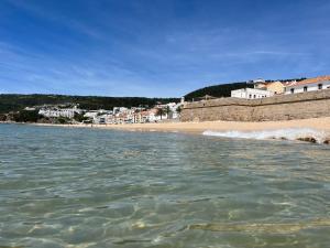 uma vista para uma praia com edifícios e a água em Apartamento Brisa do Mar em Sesimbra