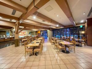 ein Restaurant mit Holztischen und -stühlen in der Unterkunft International Garden Hotel Narita in Narita