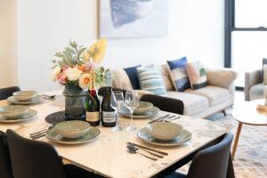 una mesa de comedor con platos y copas de vino en Mega Style Apartments Melbourne Square, en Melbourne