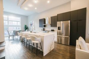a kitchen with a bar with stools and a refrigerator at MAGNIFICENT NEW Home w/8 Beds & Free Parking in Chicago