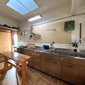 a kitchen with a sink and a wooden table at Abuden in Kumano for women and families 女性と家族専用の宿 in Kumano