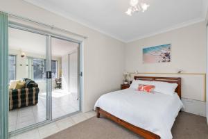 a bedroom with a bed and a sliding glass door at Bayview Towers in Nelson Bay
