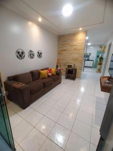 uma sala de estar com um sofá castanho e piso em azulejo em Estação 249 Caruaru (Casa de temporada) em Caruaru