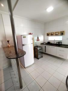 uma cozinha com um frigorífico branco e um balcão em Estação 249 Caruaru (Casa de temporada) em Caruaru