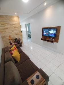 un soggiorno con divano marrone e TV a schermo piatto di Estação 249 Caruaru (Casa de temporada) a Caruaru