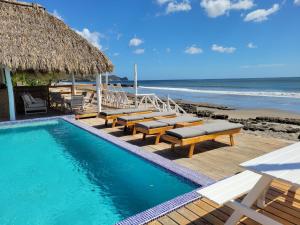 a swimming pool with benches and a beach at AZVLIK in Rivas