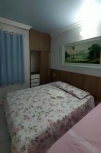 um quarto com uma cama com colcha floral em Crystal Park Flat em Aquiraz