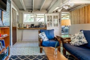 a living room with two blue chairs and a table at Waipi'o Lodge in Kukuihaele