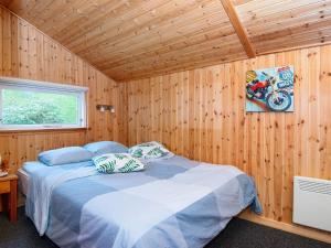 ToftlundにあるHoliday home Toftlund XIの木製の部屋にベッド1台が備わるベッドルーム1室があります。
