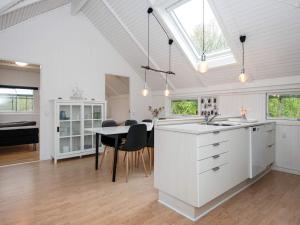a kitchen and dining room with a table and chairs at Holiday home Toftlund XI in Toftlund