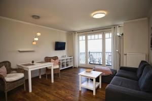 een woonkamer met een bank en een tafel bij Ferienwohnung mit traumhaftem Meerblick - Haus am Meer FeWo 07 in Lohme