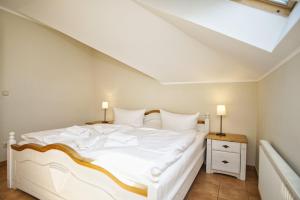 um quarto com uma cama branca e uma clarabóia em Ferienwohnung mit traumhaftem Meerblick - Haus am Meer FeWo 12 em Lohme