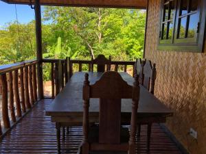 a wooden table on the porch of a house at Tanawin in El Nido