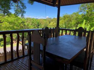 a wooden table on a deck with a view of trees at Tanawin in El Nido
