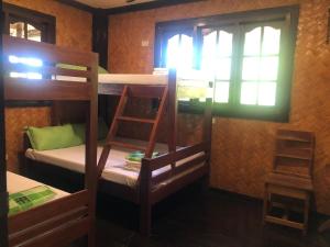 a room with two bunk beds and a window at Tanawin in El Nido