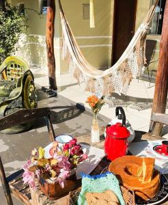 a table with food and a hammock on a patio at Pousada Nossa Senhora da Guia in Nobres