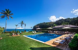 a swimming pool with lounge chairs and the ocean at Residencial Marina Del Sol in Pauba