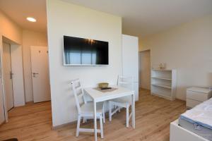 una sala da pranzo bianca con tavolo e sedie bianchi di Haus "Atlantic" Appartement ATL 604B a Cuxhaven