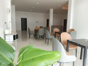 un comedor con sillas, mesas y una planta en 22 Twenty-Two Hotel ทะเวนตี้-ทู โฮเทล, en Ban Pa Muat