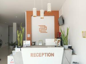 a reception desk with a sign that reads reception at 22 Twenty-Two Hotel ทะเวนตี้-ทู โฮเทล in Ban Pa Muat