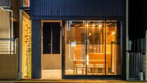 une porte en verre d'un bâtiment avec une table et des chaises dans l'établissement ALPHABED INN Fukuoka Ohori Park, à Fukuoka
