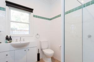 a white bathroom with a toilet and a sink at Ventnor Cosy Homestead in Ventnor +12 photos