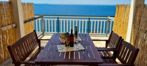 a wooden table with bottles of wine on a balcony at Apartments Ana i Ante Punta in Milna