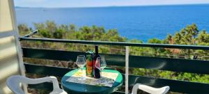 a table with two glasses and a bottle of wine at Apartments Ana i Ante Punta in Milna