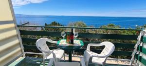 a table and chairs on a balcony with the ocean at Apartments Ana i Ante Punta in Milna